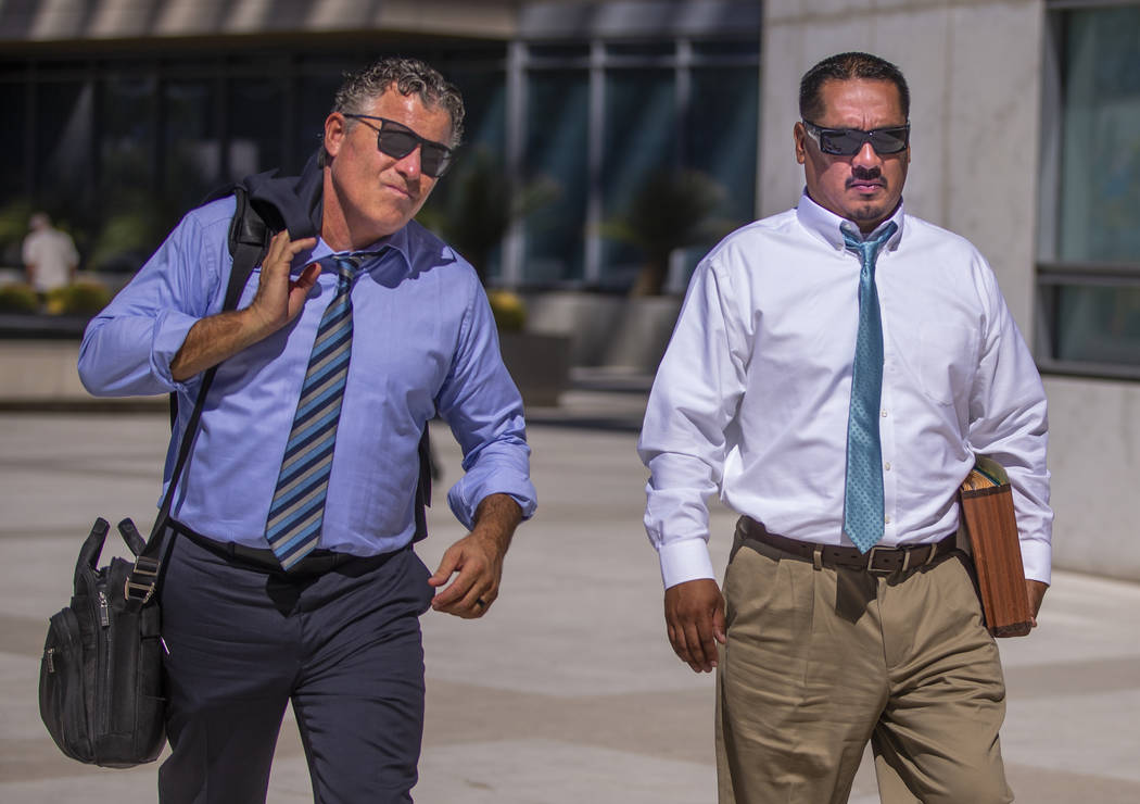Lawyer Mark Fleming, left, walks with defendant Albert Lopez outside the Lloyd D. George Courth ...