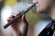 In an Oct. 4, 2019, file photo, a woman using an electronic cigarette exhales in Mayfield Heigh ...