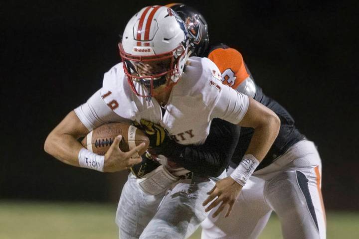 Liberty junior quarterback Daniel Britt (18) tries to break free from Chaparral senior lineback ...