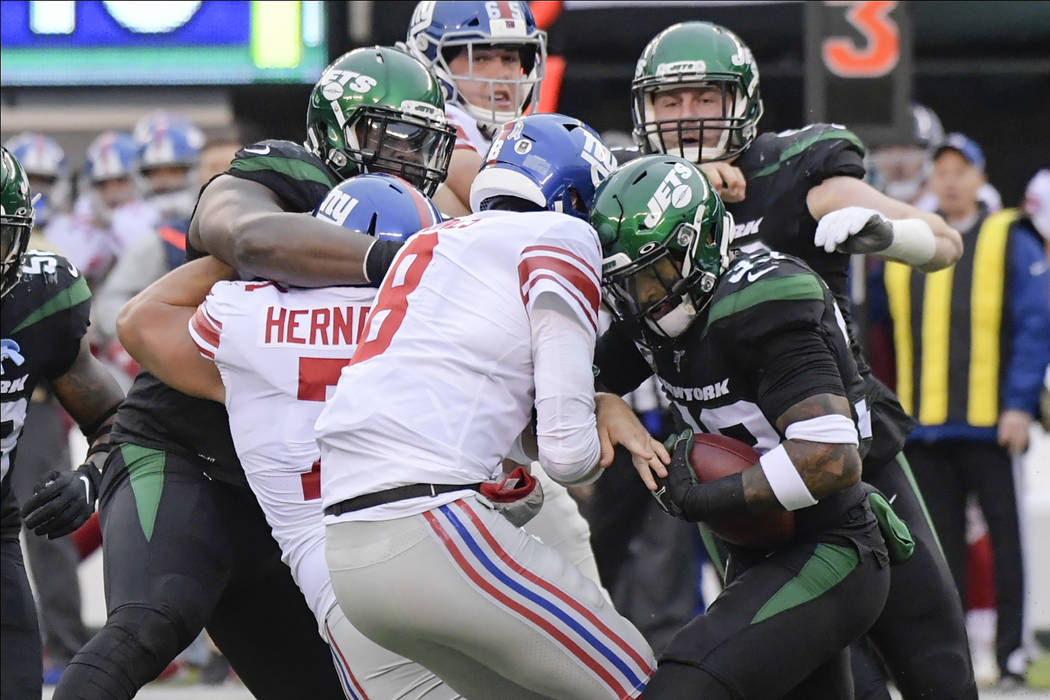 New York Jets strong safety Jamal Adams, right, strips the ball from New York Giants quarterbac ...