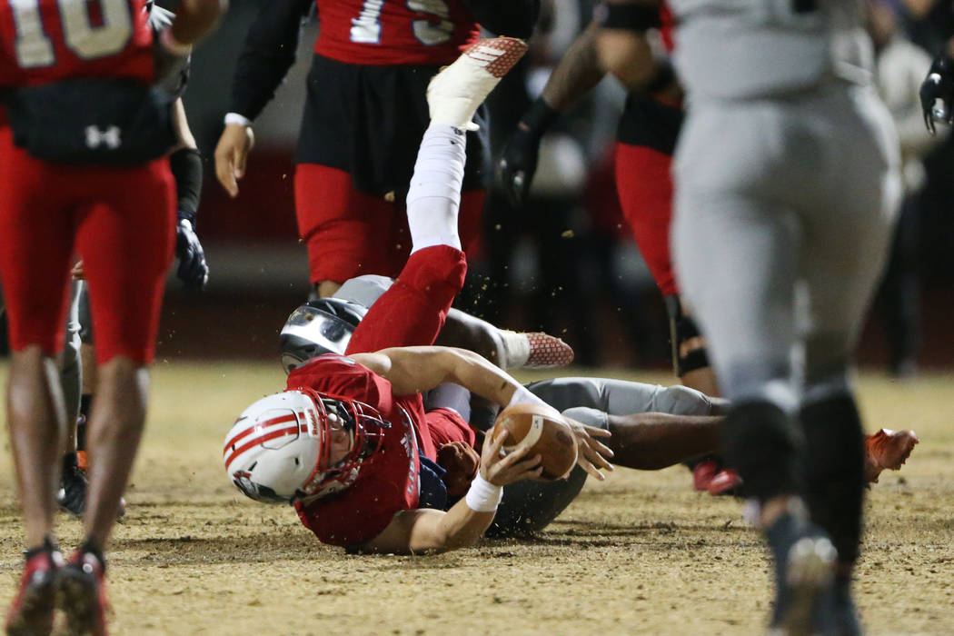 Liberty's quarterback Daniel Britt (18), is tackled by Bishop Gorman's Bryan Certain (24), in t ...