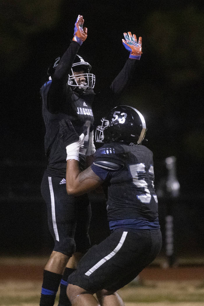 Desert Pines' Tiaoalii Savea (53) lifts up Deandre Moore (2) after Moore scored a touchdown aga ...