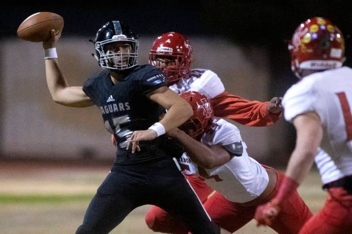 Desert Pines' quarterback Rjay Tagataese (15) looks to throw the ball as Arbor View's Zavier Al ...