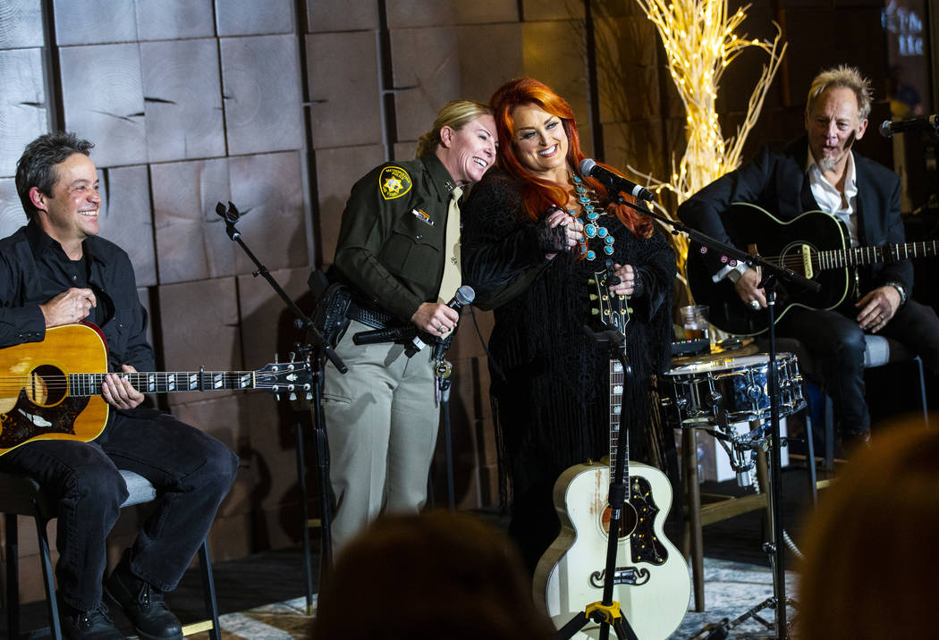 Metropolitan Police Department Capt. Kelly McMahill, second from left, embraces singer-songwrit ...