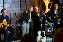 Metropolitan Police Department Capt. Kelly McMahill, second from left, embraces singer-songwrit ...