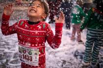 Sydney Buy, 6, of Las Vegas, plays in the fake snow at the seventh annual PJ 5K & 1-Mile Walk o ...