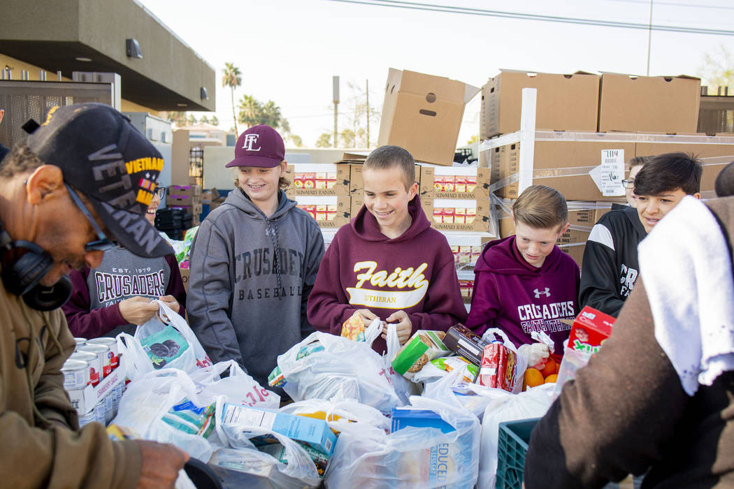 Faith Lutheran Middle School students hand out food variety packs while volunteering at Luthera ...