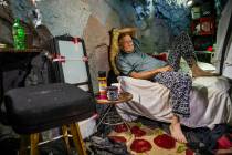 Richard Roman relaxes on his bed while living in a former mine in the hillside above the River ...