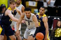 Colorado guard Tyler Bey, center, loses control of the ball after UC Irvine guard Evan Leonard, ...