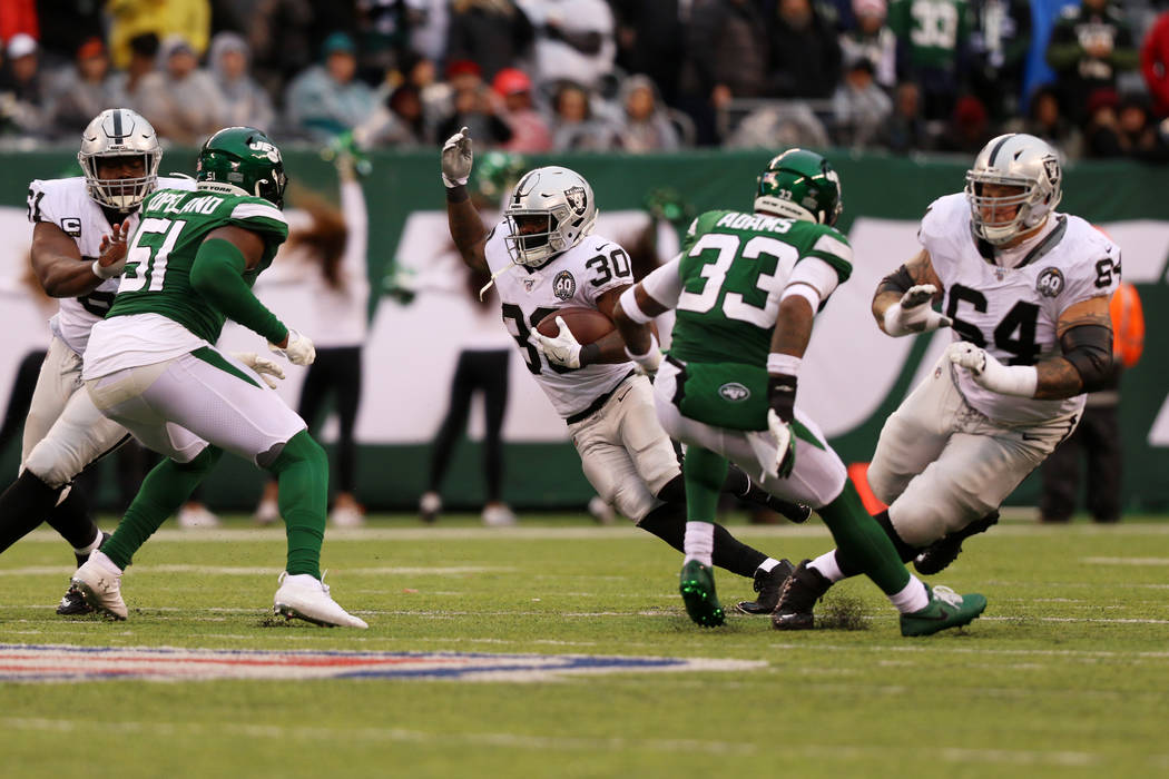 Oakland Raiders running back Jalen Richard (30) looks for room to run as center Rodney Hudson ( ...