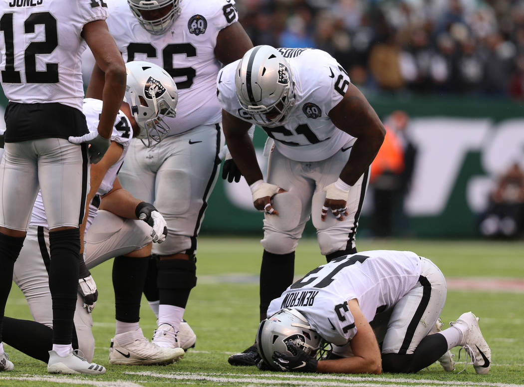 Oakland Raiders wide receiver Hunter Renfrow (13) remains on the field after colliding with a N ...