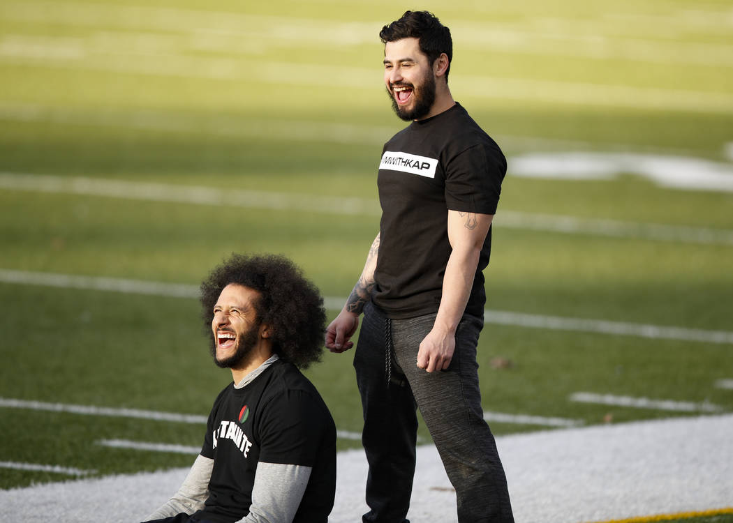 Free agent quarterback Colin Kaepernick, left, laughs will stretching before a workout for NFL ...