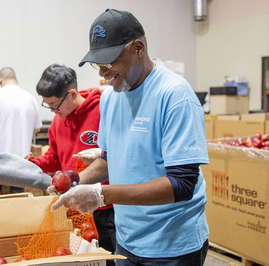 Volunteers with Diamond Resorts Kai Tran, 12, North Las Vegas, left, and Darrick Cunningham, pa ...