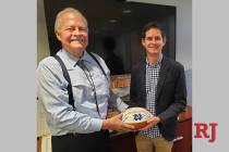 Las Vegas attorneys John Mowbray and son Tyler are shown with an autographed Notre Dame footbal ...