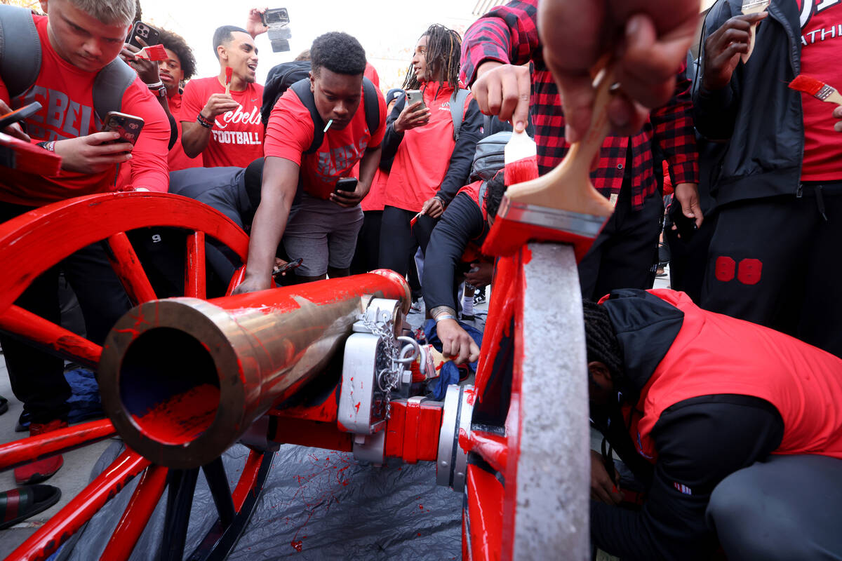 UNLV Football players paint the Fremont Cannon red during a celebration on campus Monday, Nov. ...