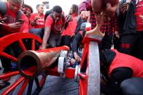 UNLV Football players paint the Fremont Cannon red during a celebration on campus Monday, Nov. ...