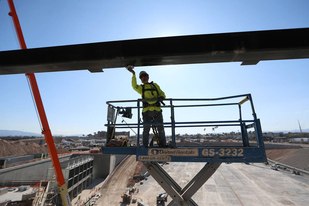 A worker paints a piece of structure of the Raiders Allegiant Stadium in Las Vegas, Monday, Nov ...