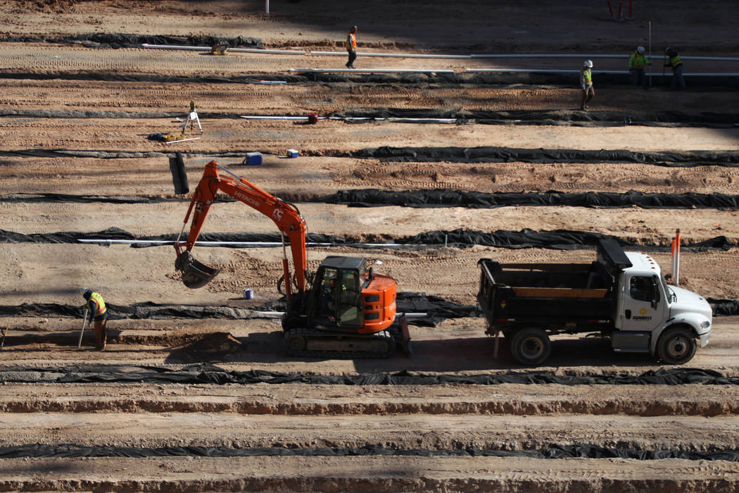 Workers on the field level of the Raiders Allegiant Stadium construction site in Las Vegas, Mon ...