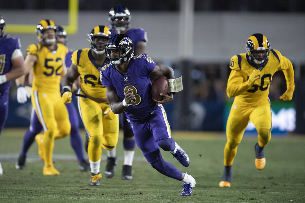 Baltimore Ravens quarterback Lamar Jackson runs against the Los Angeles Rams during the first h ...