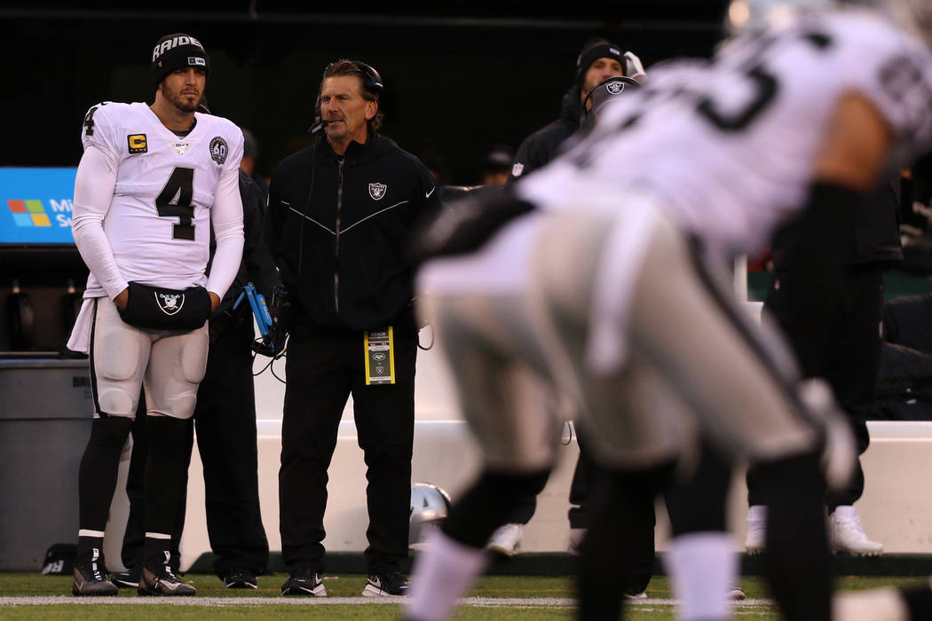 Oakland Raiders quarterback Derek Carr (4) watches from the sideline with offensive coordinator ...