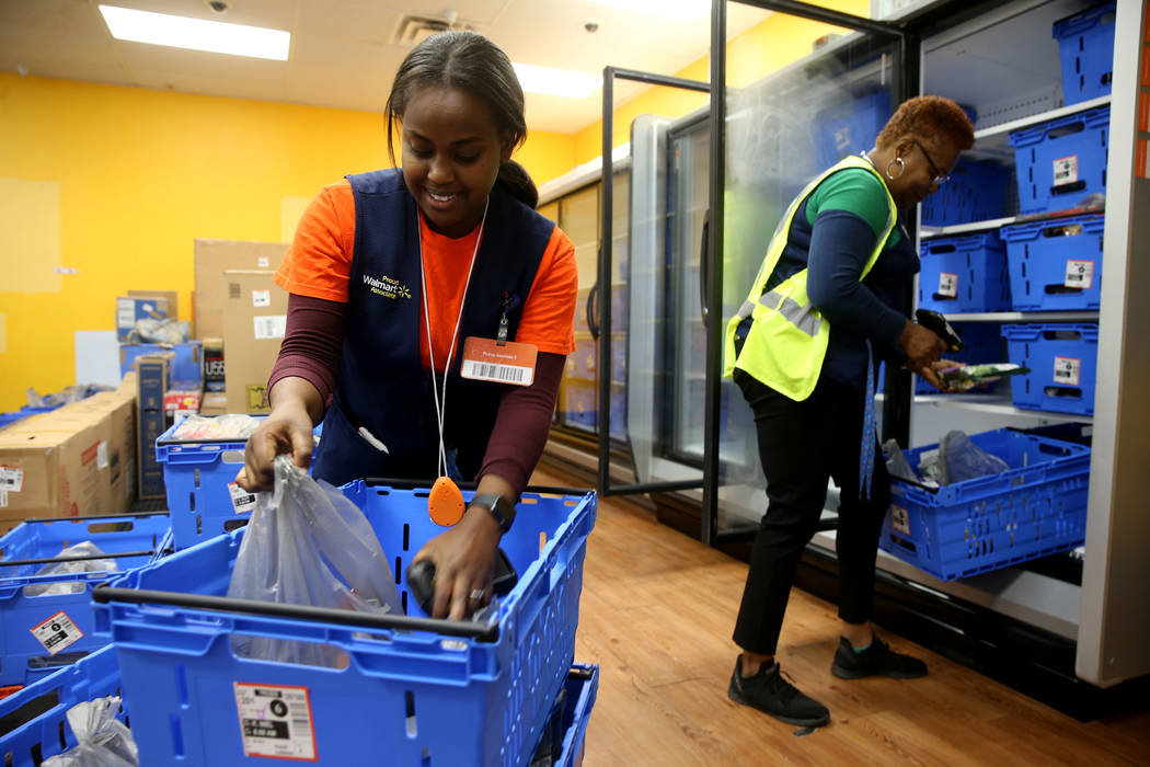 Personal shoppers Mety Woldeyes, left, and Gloria Mitchell prepare customer merchandise pickup ...