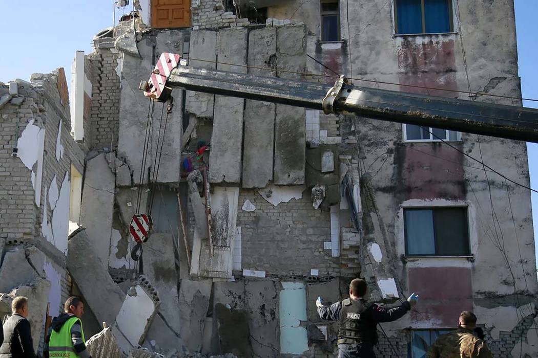 Rescuers search at a damaged building after a magnitude 6.4 earthquake in Thumane, western Alba ...