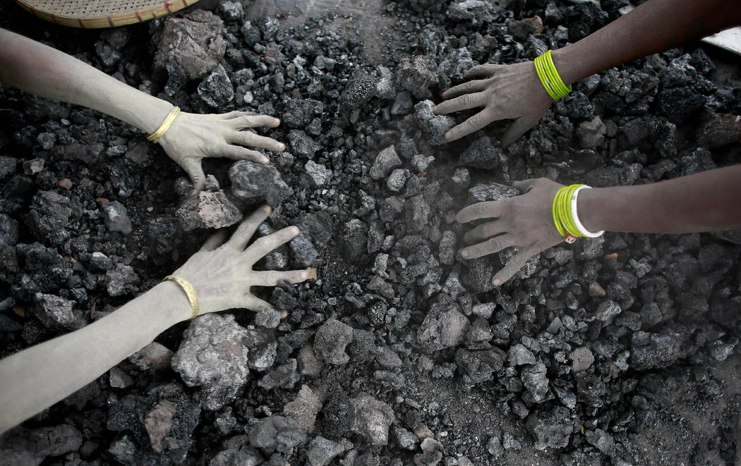 FILE - In this Monday, Dec. 14, 2015, file photo, Indian women use bare hands to pick reusable ...