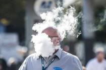 In this Jan. 23, 2019, file photo, Derick Rainey takes a vape break outside the Las Vegas Conve ...