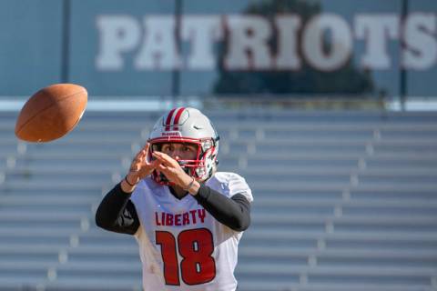Liberty's quarterback Daniel Britt (18) is about to catch the ball during practice on Tuesday, ...