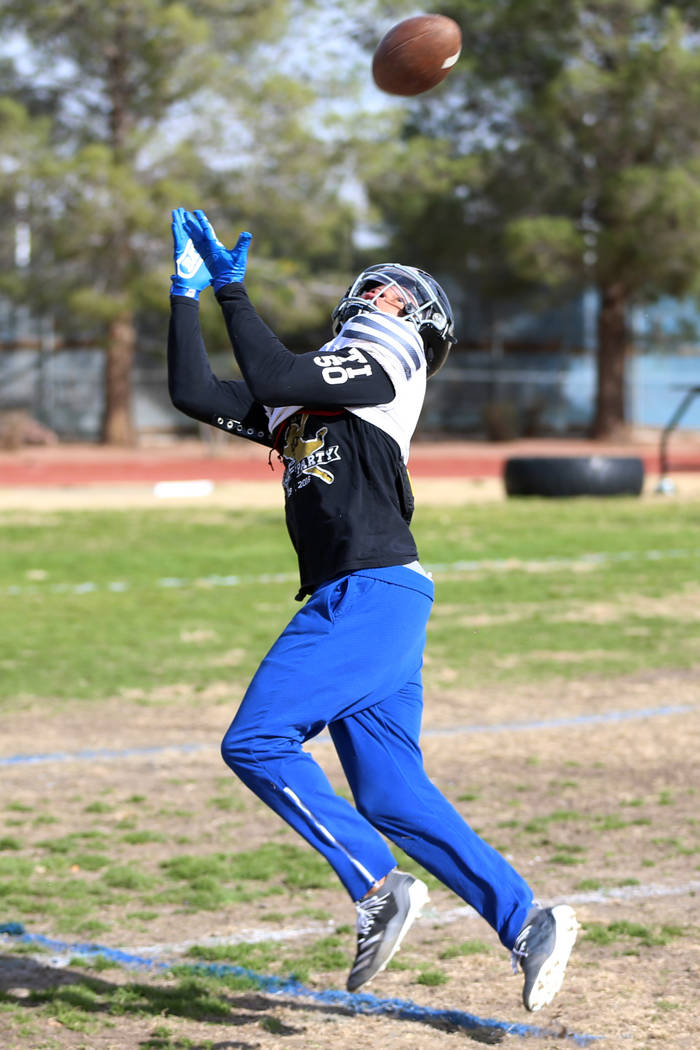 Desert Pines' Michael Jackson (13) reaches for a catch during a team practice at Desert Pines H ...