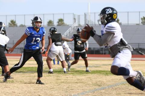 Desert Pines' Rjay Tagataese (15) hands off the ball to DeAvonte McGee (20) for a run during a ...