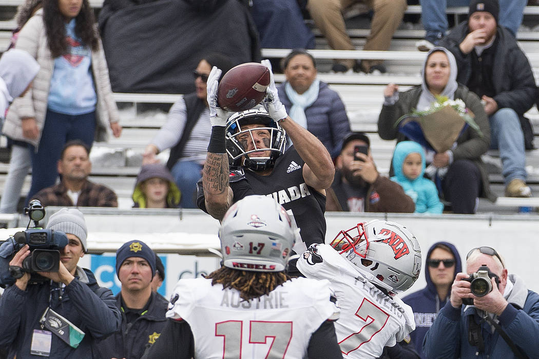 Nevada wide receiver Elijah Cooks, top, goes up for a pass over UNLV's Jericho Flowers (7) in t ...