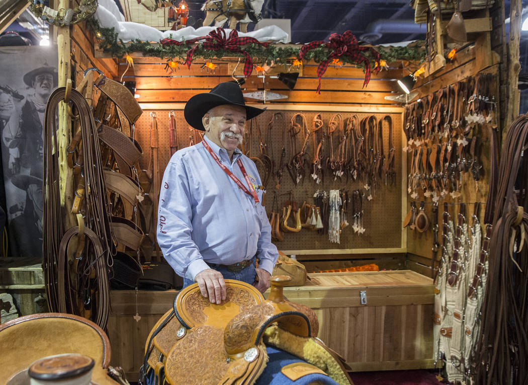 Tommy Conway stands by a group of his custom-made saddles at Cowboy Up Saddles during Cowboy Ch ...