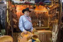 Tommy Conway stands by a group of his custom-made saddles at Cowboy Up Saddles during Cowboy Ch ...