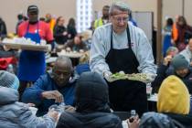 Volunteer Alan Kotwica, top/right, serves a tray of food during the Las Vegas Rescue Mission's ...