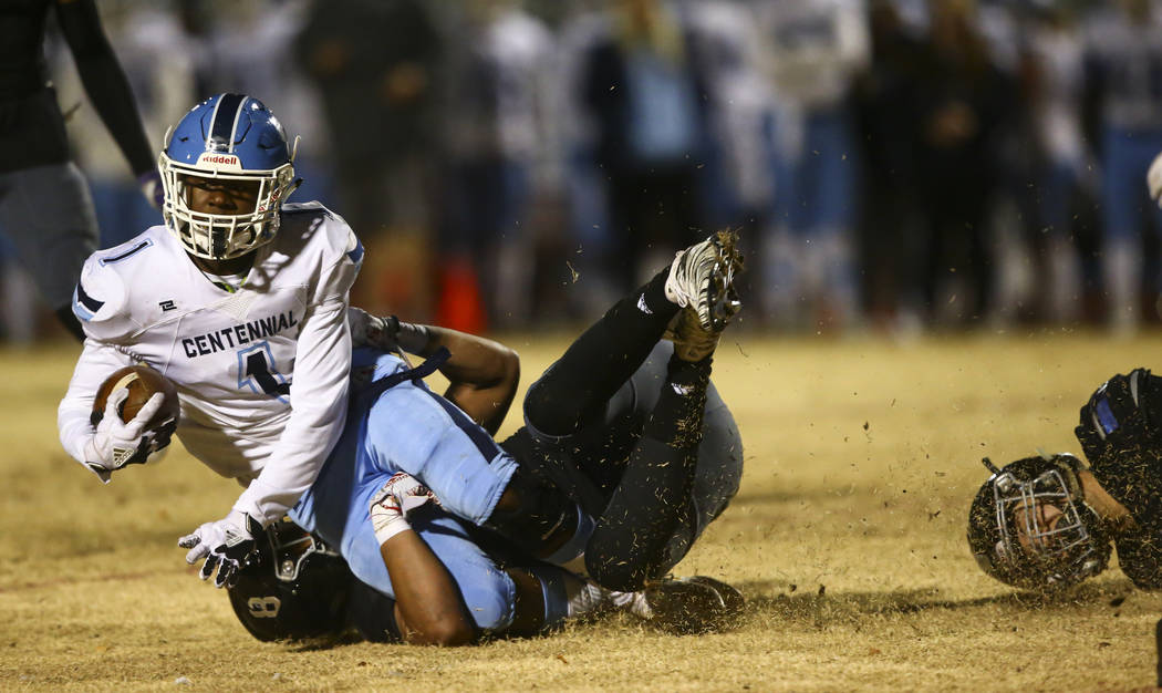 Centennial's Jordan Smith (1) gets stopped by Desert Pines' Will Paden (8) during the second ha ...