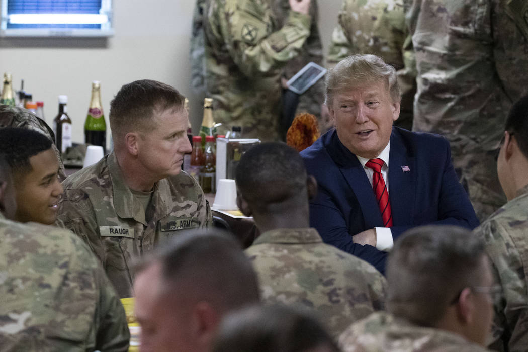 President Donald Trump speaks with members of the military during a surprise Thanksgiving Day v ...