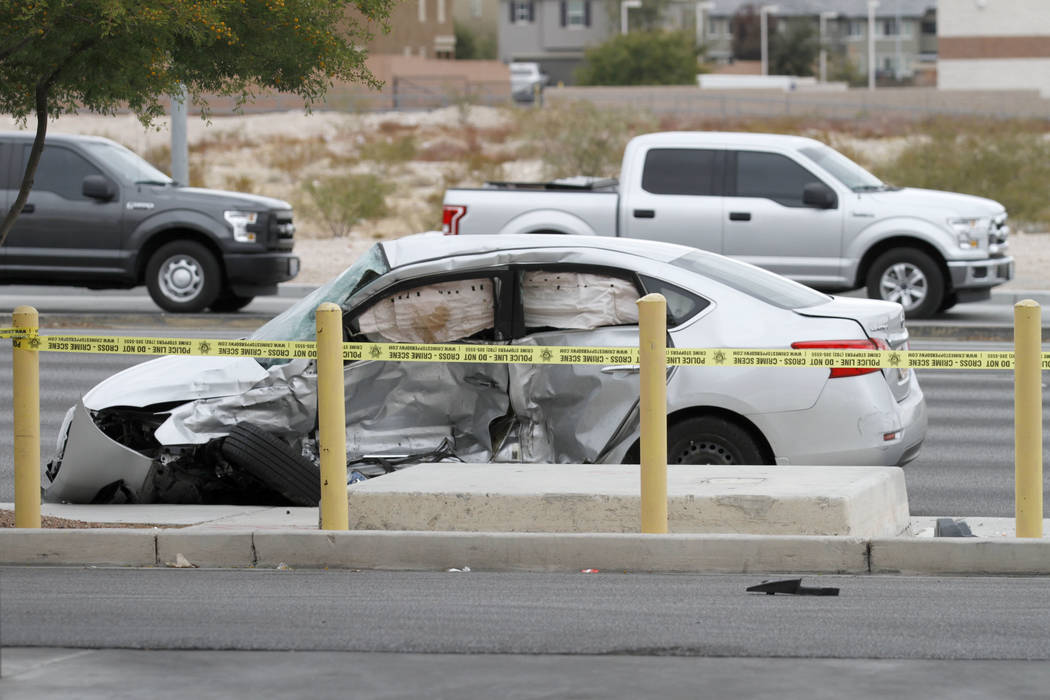 Las Vegas police officers investigate a fatal crash at Durango Drive and Russell Road in southw ...