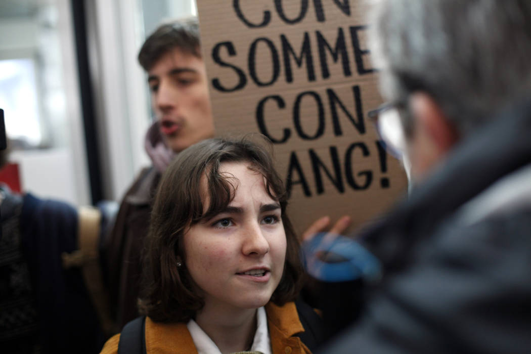 An activist blocks a shopping center, in the business district of Paris, La Défense, in Pa ...