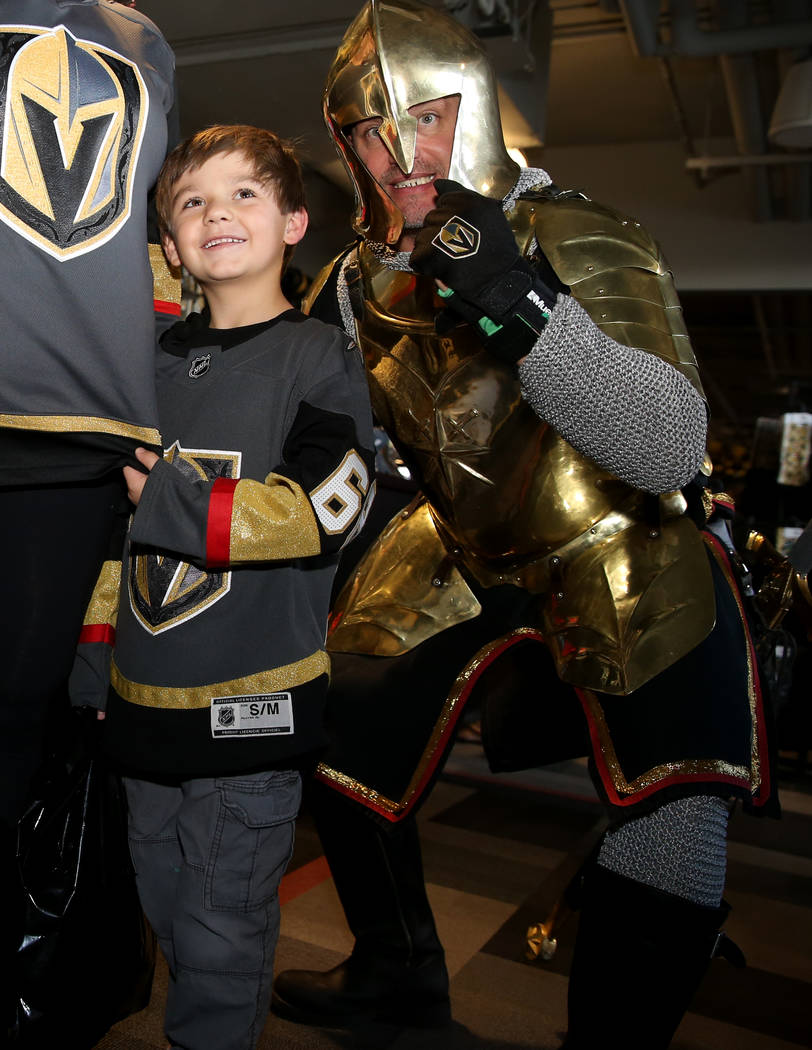 Silus Wells, 5, poses with The Golden Knight at The Arsenal retail store at City National Arena ...