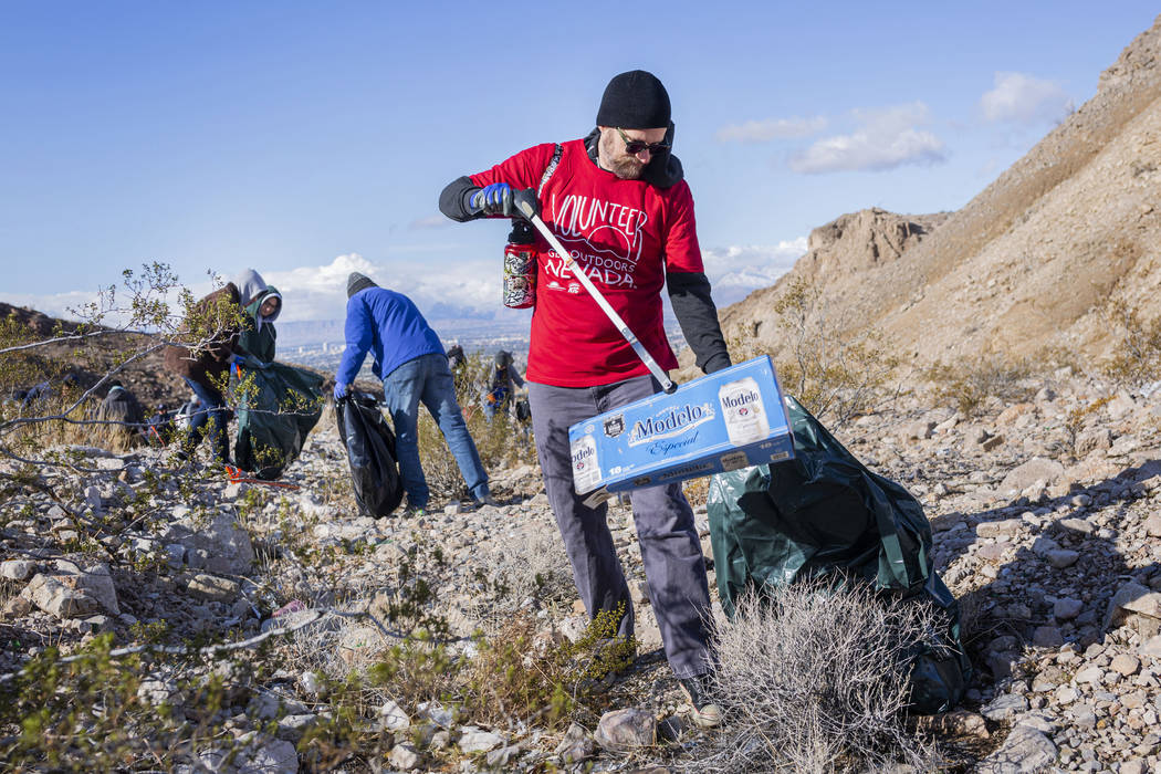 Volunteer for Get Outdoors Nevada Chris Moore picks up garbage near the trail leading to the Gr ...
