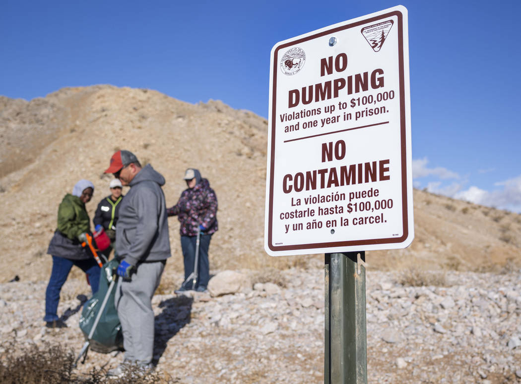 Volunteers for Get Outdoors Nevada clean up garbage near the trail leading to the Great Unconfo ...