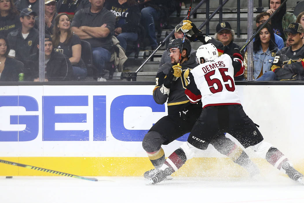 Golden Knights' William Carrier, left, and Arizona Coyotes' Jason Demers (55) battle to reach t ...