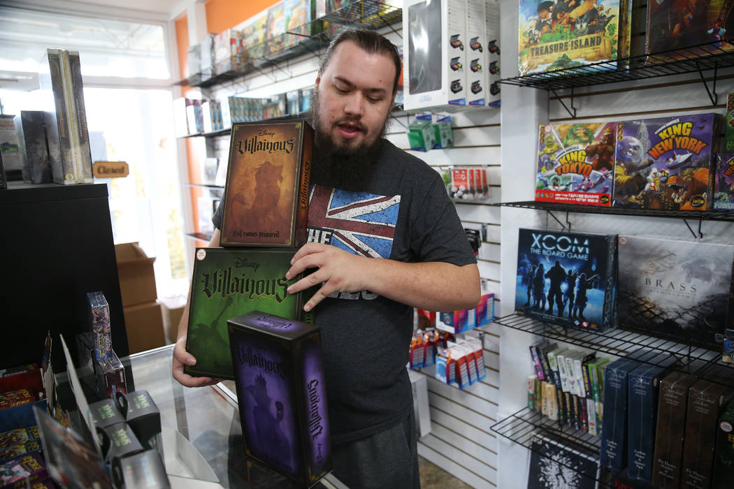 Ryan Champion, co-owner of The Gaming Goat, shows a board game for sale inside his business at ...