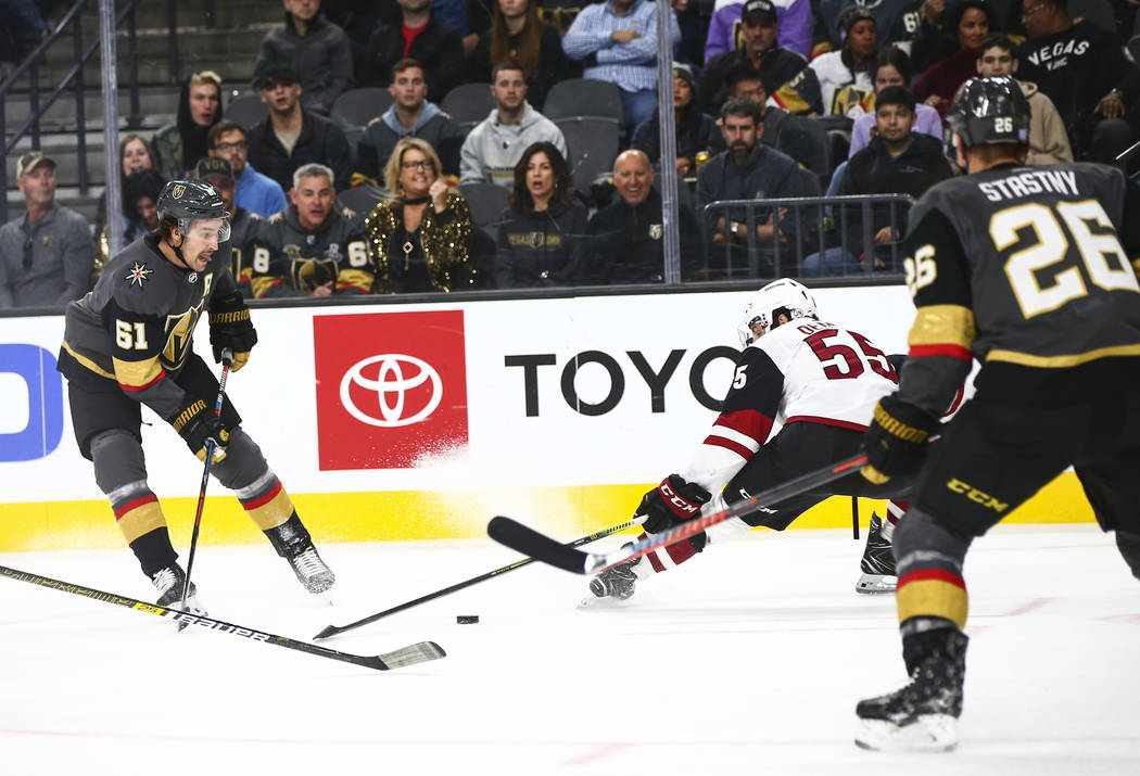 Golden Knights' Mark Stone (61) sends the puck past Arizona Coyotes' Jason Demers (55) during t ...