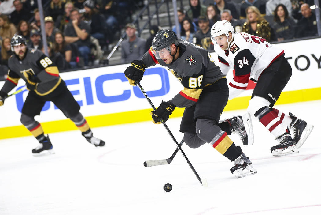 Golden Knights' Nate Schmidt (88) skates with the puck in front of Arizona Coyotes' Carl Soderb ...