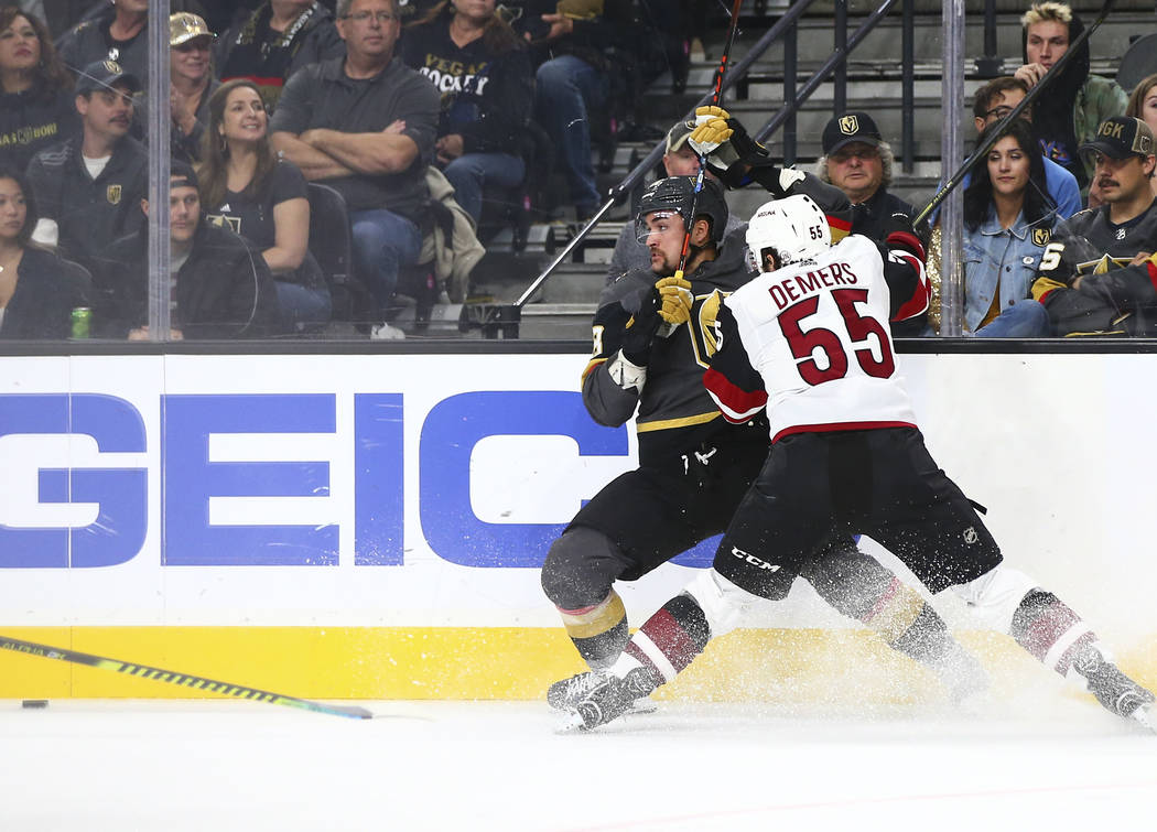 Golden Knights' William Carrier, left, and Arizona Coyotes' Jason Demers (55) battle to reach t ...