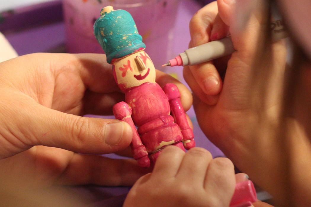 Harley Taylor, 5, of Las Vegas, paints a nutcracker ornament during the Discovery Children's Mu ...