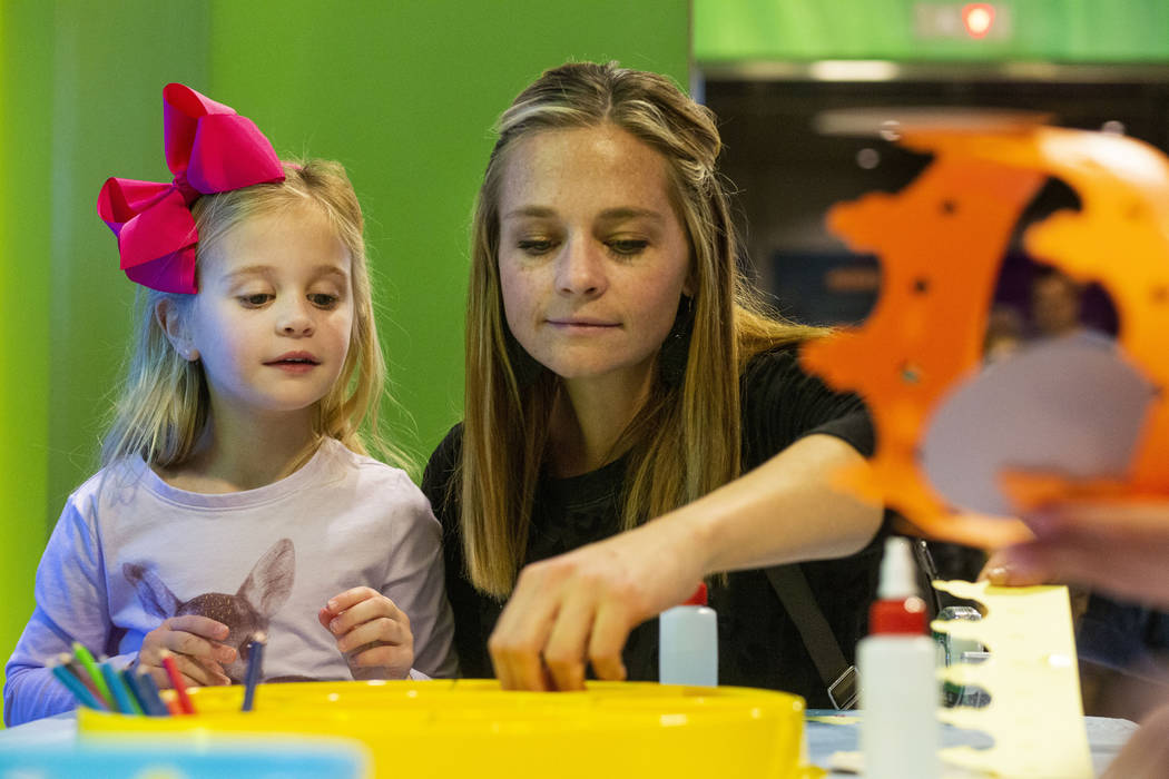 Addison Piraino, 5, left, and Sophia Piraino of Denver make craft crowns at the Discovery Child ...