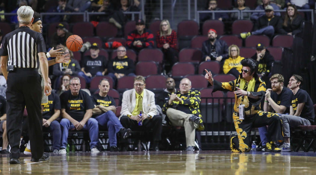 University of Iowa fan Greg Suckow, dressed as Elvis, tosses the ball back into play during the ...